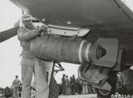 Asisbiz P 51D Mustang 7AF 15FG47FS armorer adjusts the sway braces to carry the 500lb bomb at Iwo Jima 1945 01