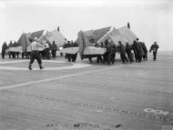 Asisbiz Fleet Air Arm Martlets aboard HMS Pursuer being manhandled on to the lift to be carried below 1944 IWM A23061